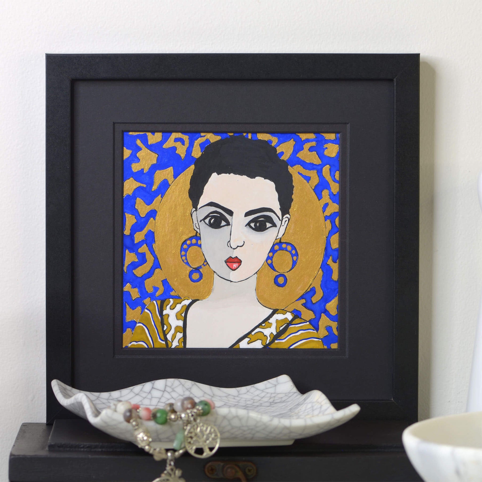 Small, original gouache painting of spiritual feminine power and beauty with golden detail by Ella Que Artist in black single mat